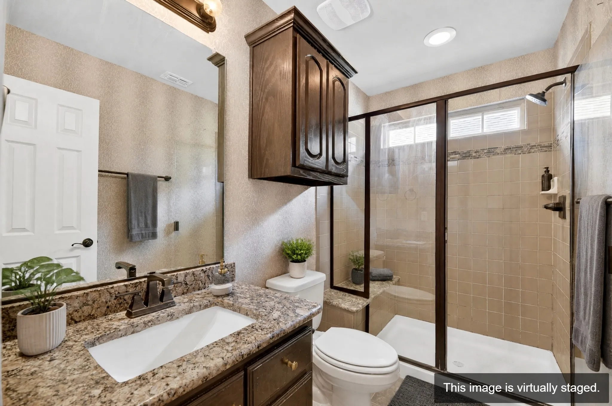Bathroom featuring a shower with glass enclosure, beige tiled walls, and a built-in bench