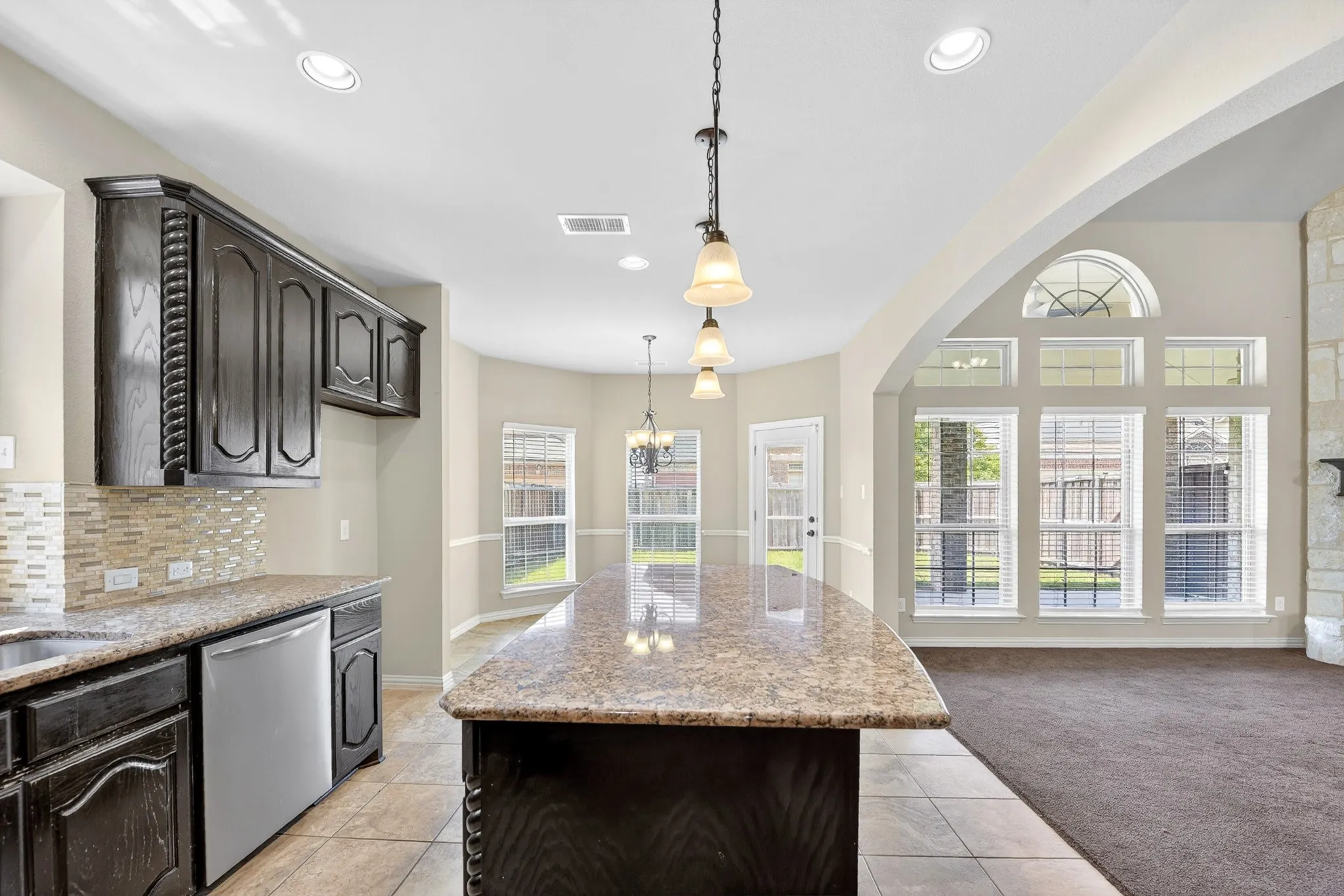 The property features a kitchen with dark cabinetry, granite countertops, and a tiled​​‌​​​​‌​​‌‌​‌‌​​​‌‌​‌​‌​‌​​​‌​​ backsplash
