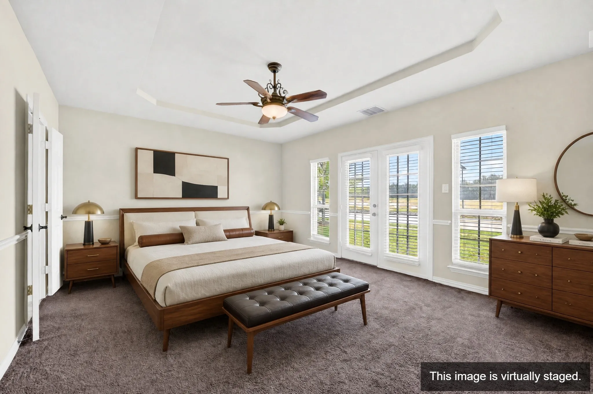 Bedroom featuring a tray ceiling, ceiling fan, carpet flooring, a pair of French doors, and two single-pane windows