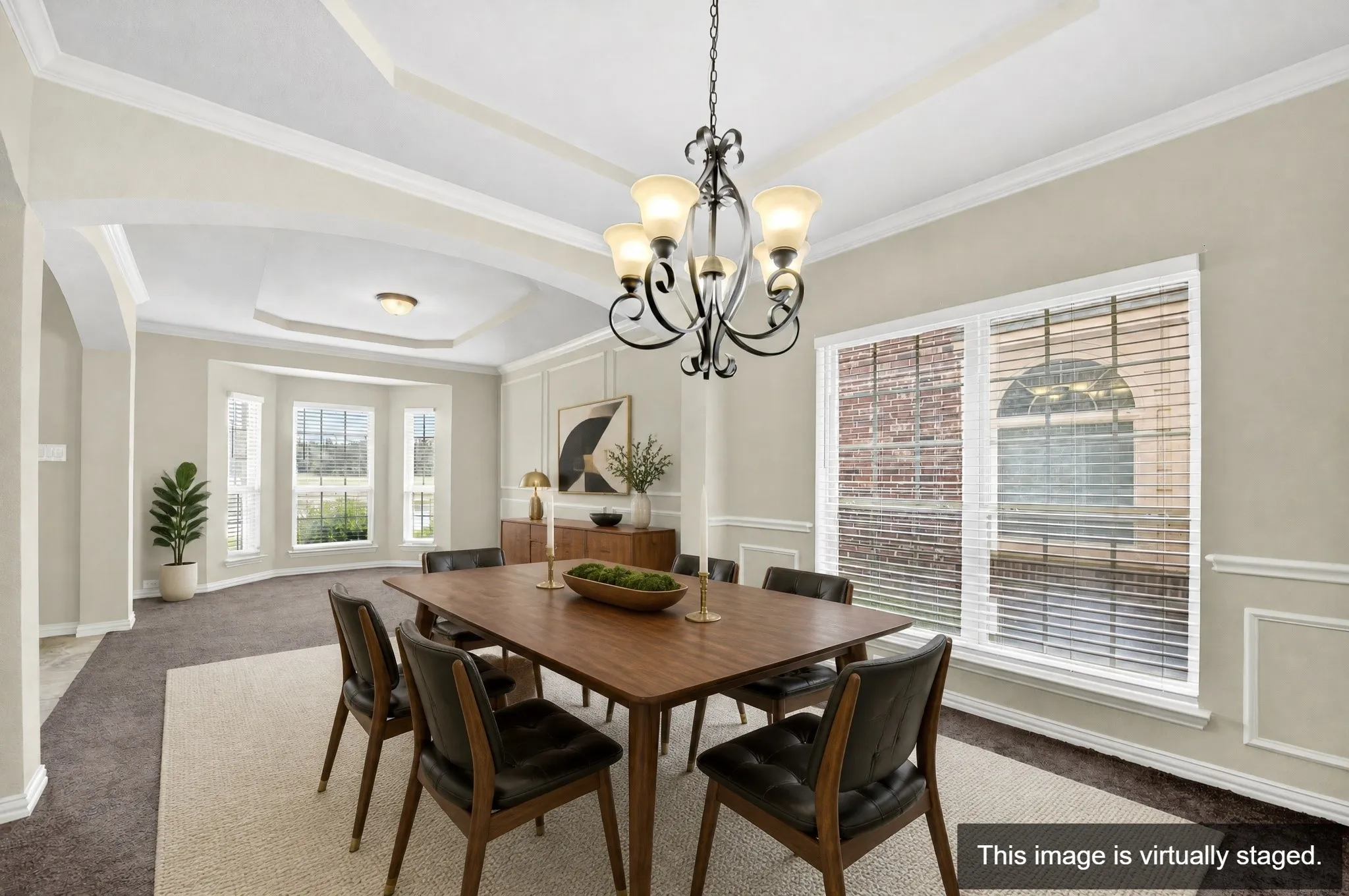 Dining space with a tray ceiling, arched entryways, and crown molding