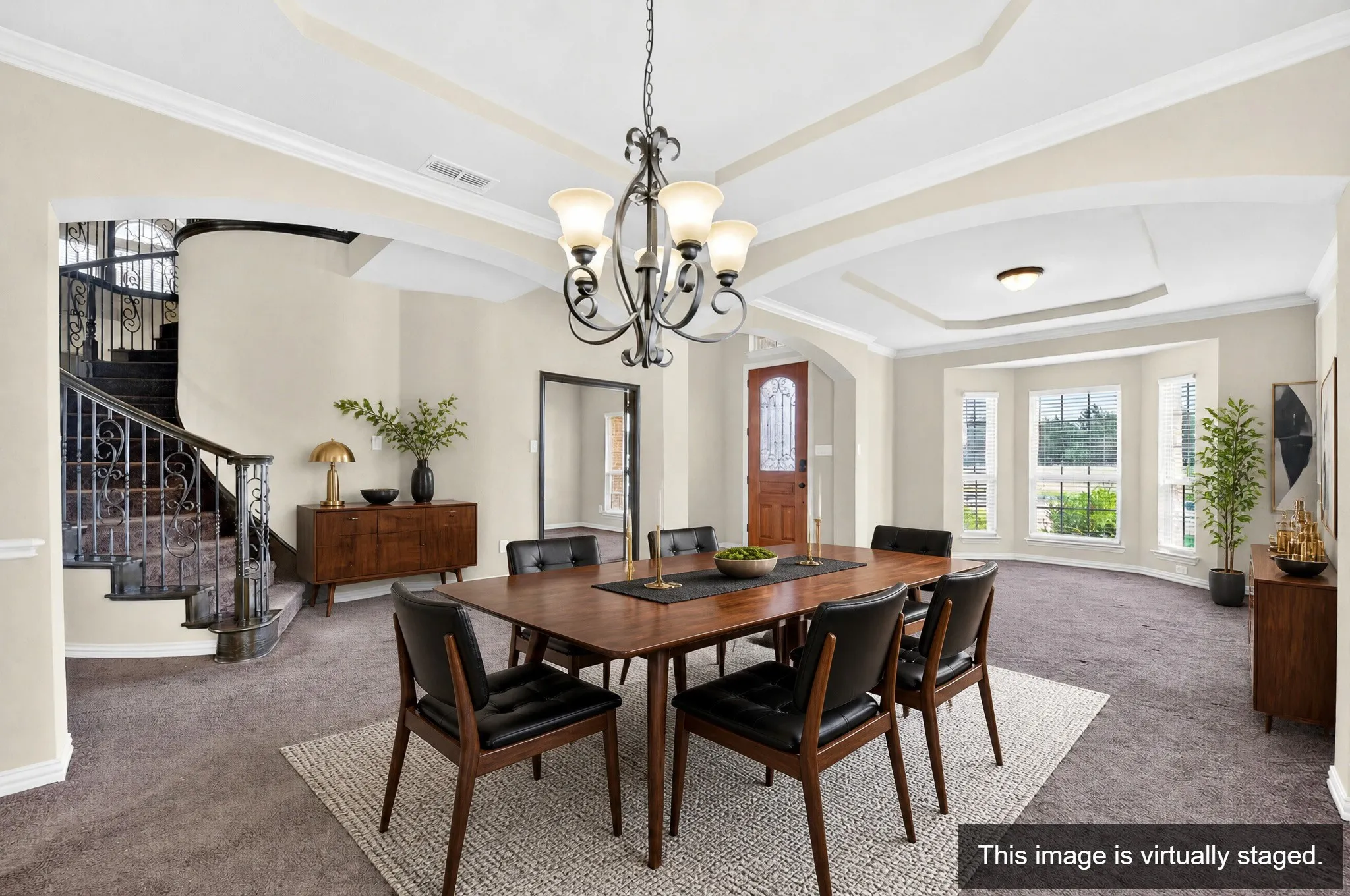 Formal dining area featuring a tray ceiling with crown molding and an ornate chandelier