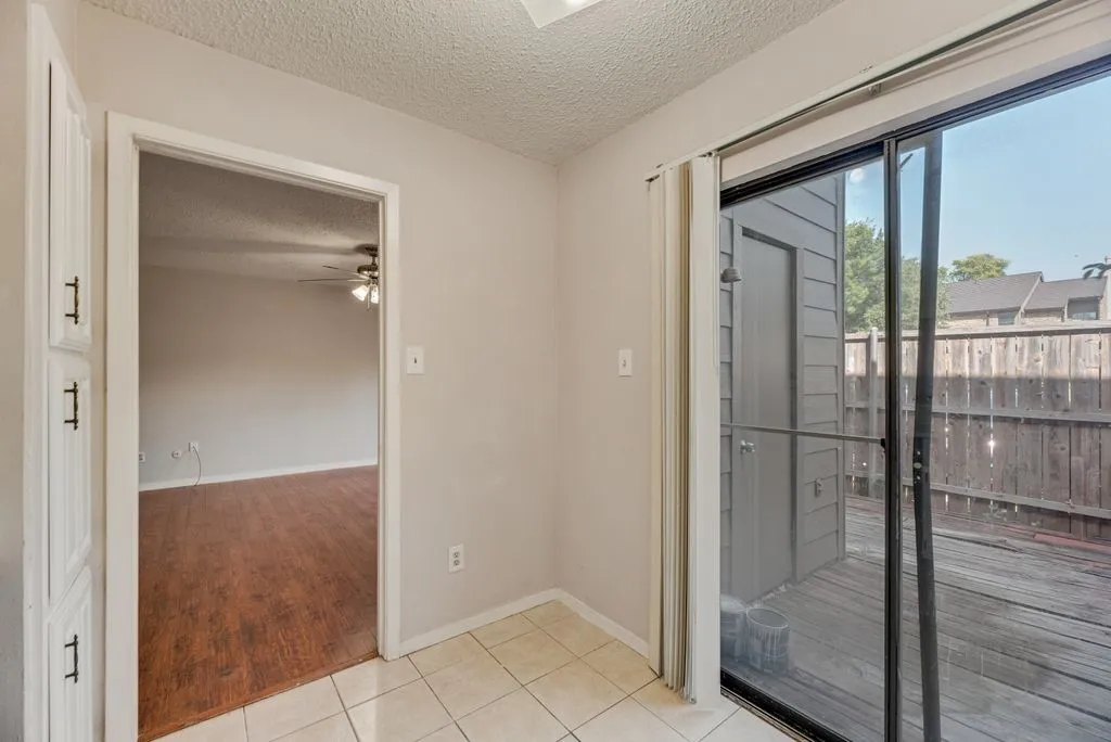 Unfurnished room featuring a textured ceiling, ceiling fan, and light tile patterned floors