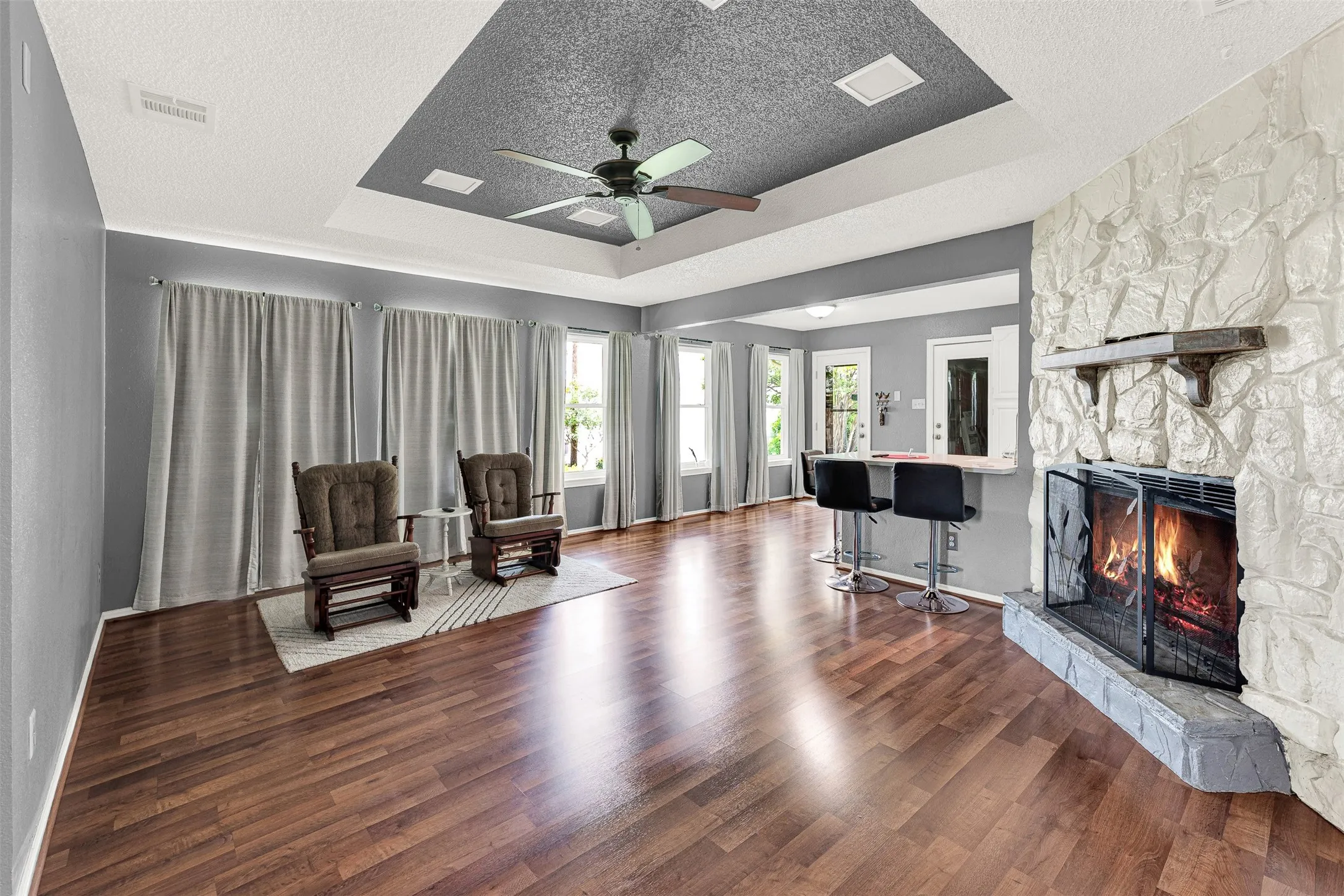 NOT staged  - Big living area with great windows for tons of light, wonderful floors, coffered ceiling and rock, wood burning fireplace, great for those cozy winters.