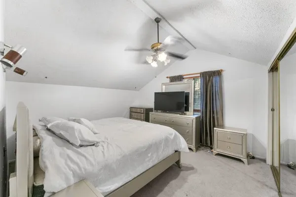 Bedroom featuring carpet flooring, ceiling fan, a closet, and a textured ceiling