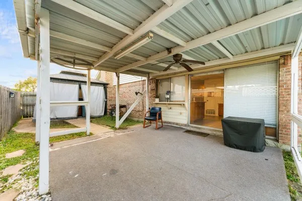 Fenced backyard with a patio area and ceiling fan
