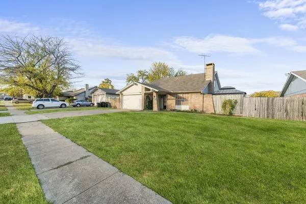 View of front of home with concrete driveway, a chimney, and an attached garage