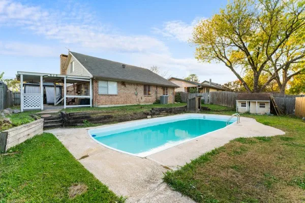 View of pool with a fenced backyard, a patio, and a storage shed