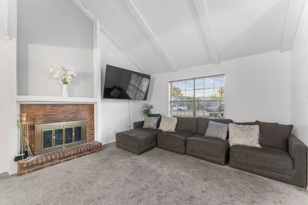 Carpeted living area featuring a fireplace