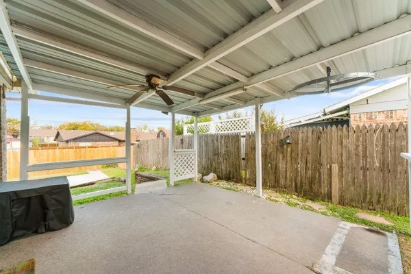 Fenced backyard with ceiling fan and a patio area