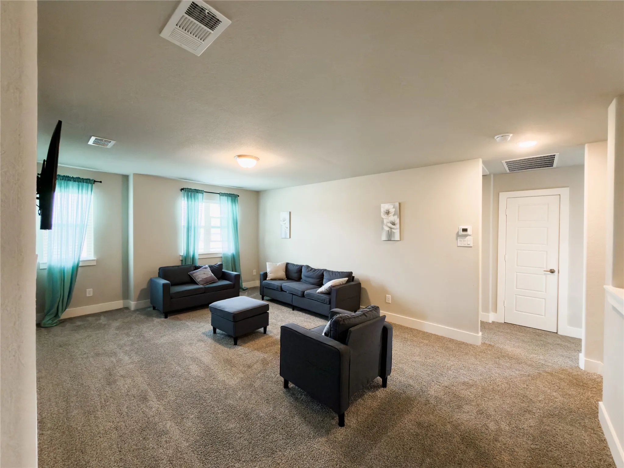 Living area featuring light colored carpet and baseboards