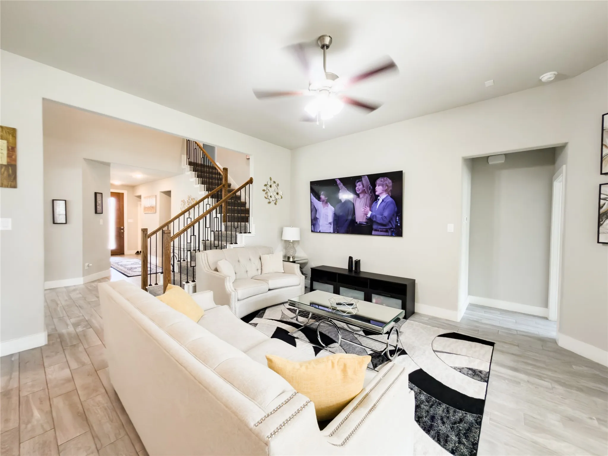 Living room with light wood-style flooring and a ceiling fan