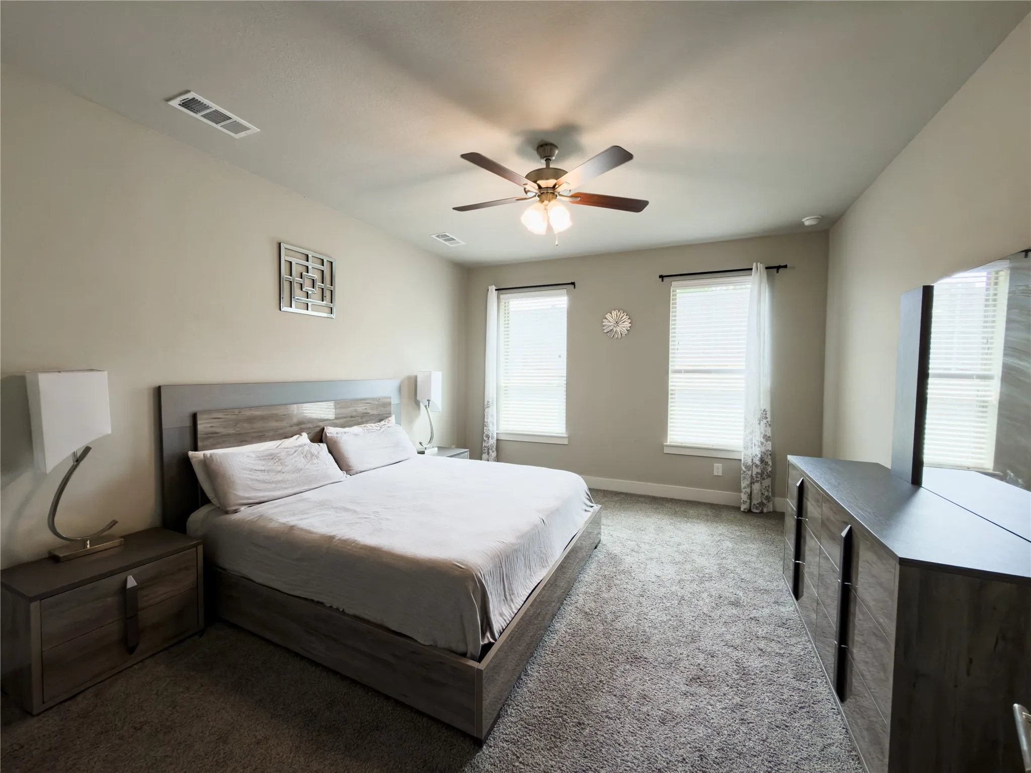Carpeted bedroom featuring a ceiling fan and baseboards