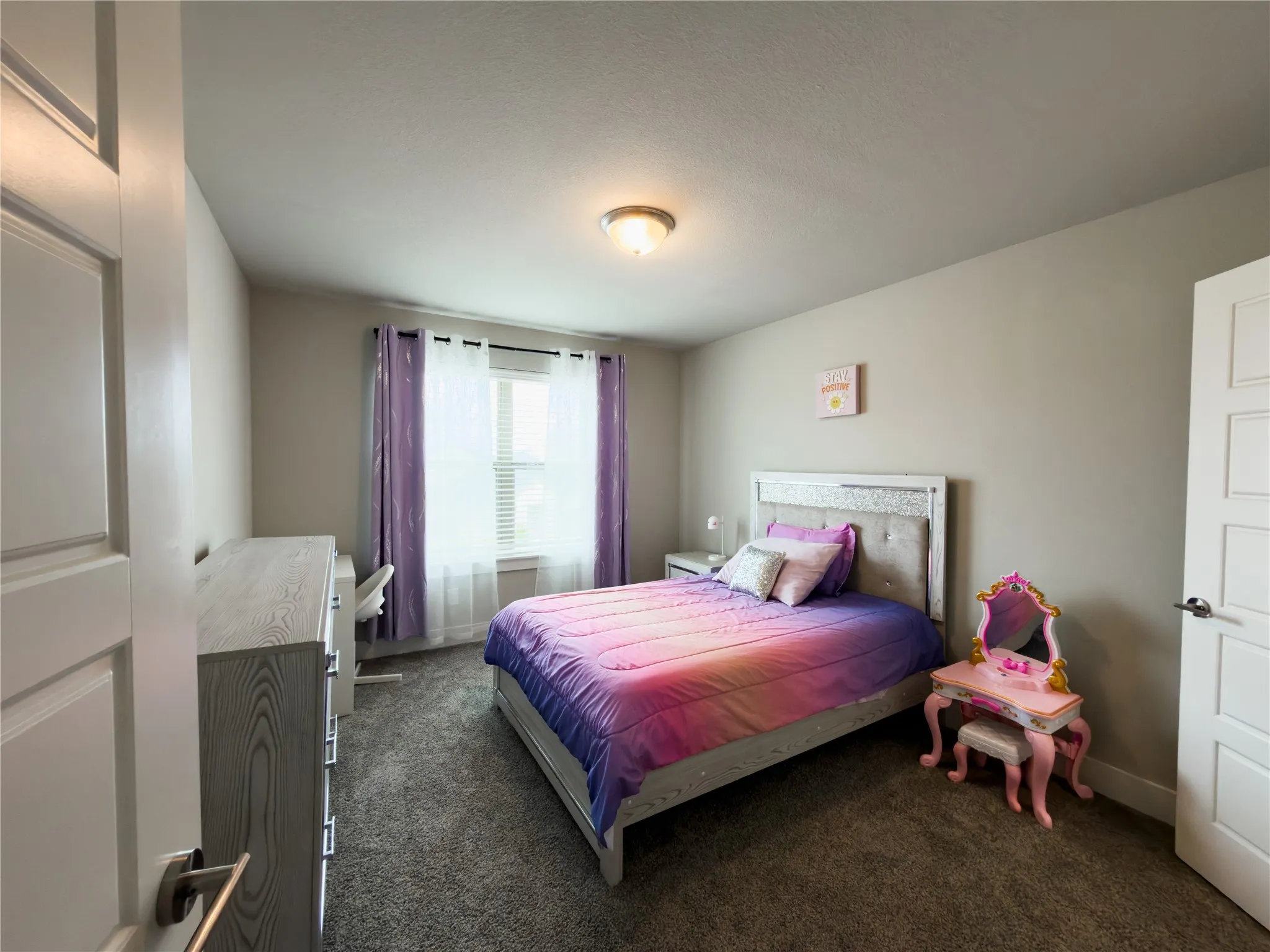 Bedroom with dark colored carpet and baseboards