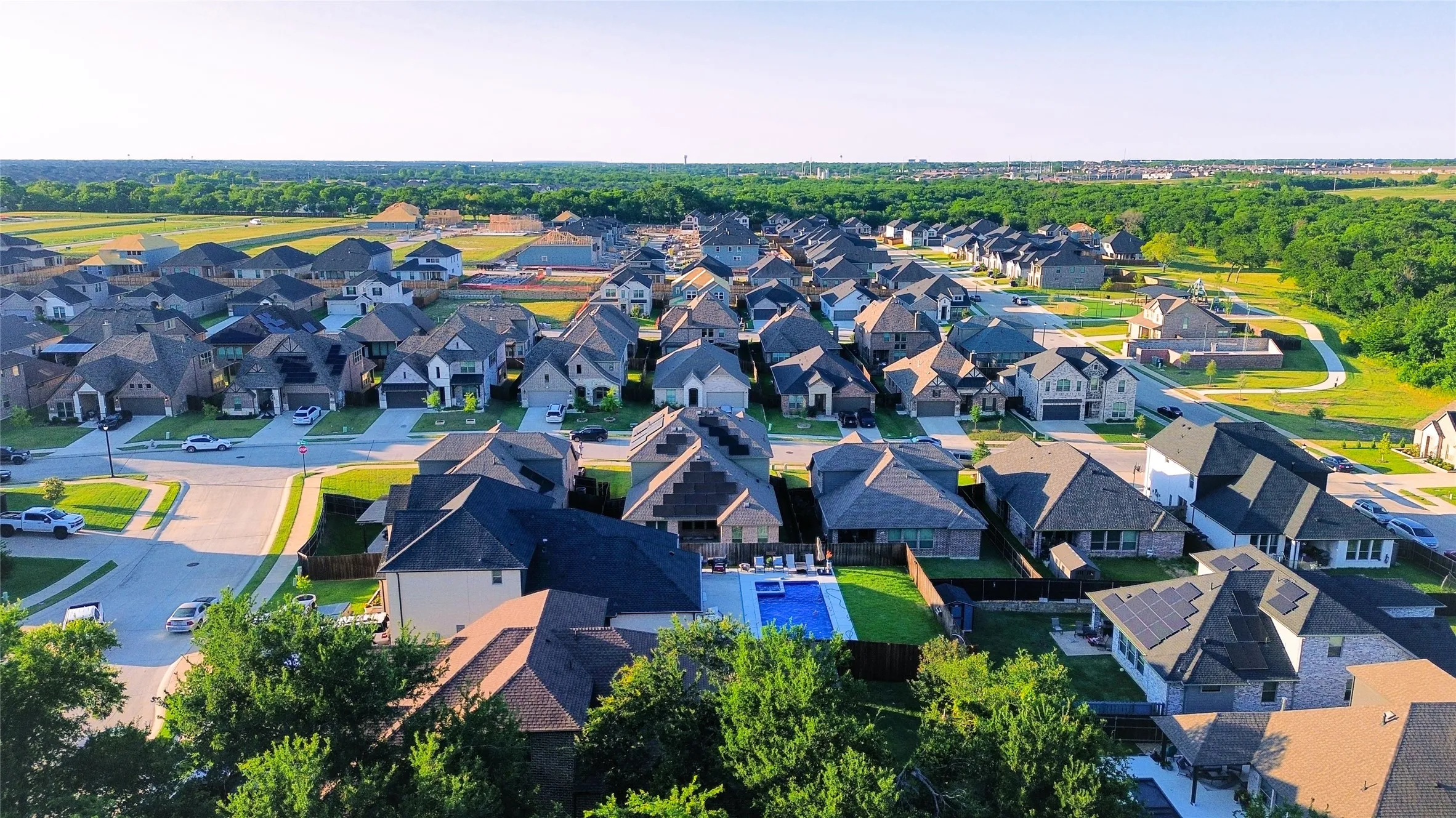 Residential street with established homes, green lawns, and mature trees