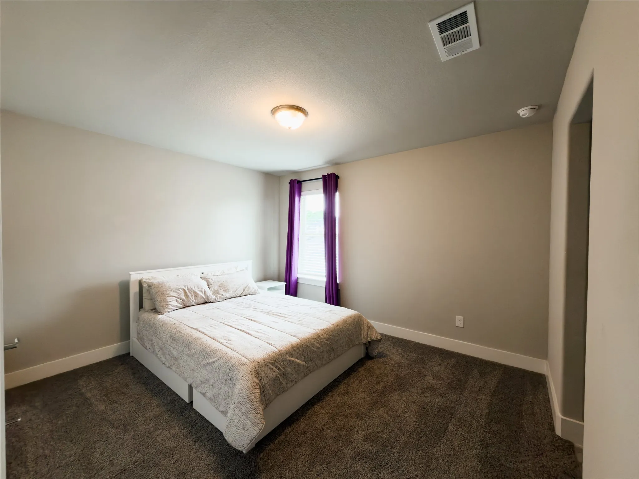 Bedroom featuring baseboards and dark colored carpet