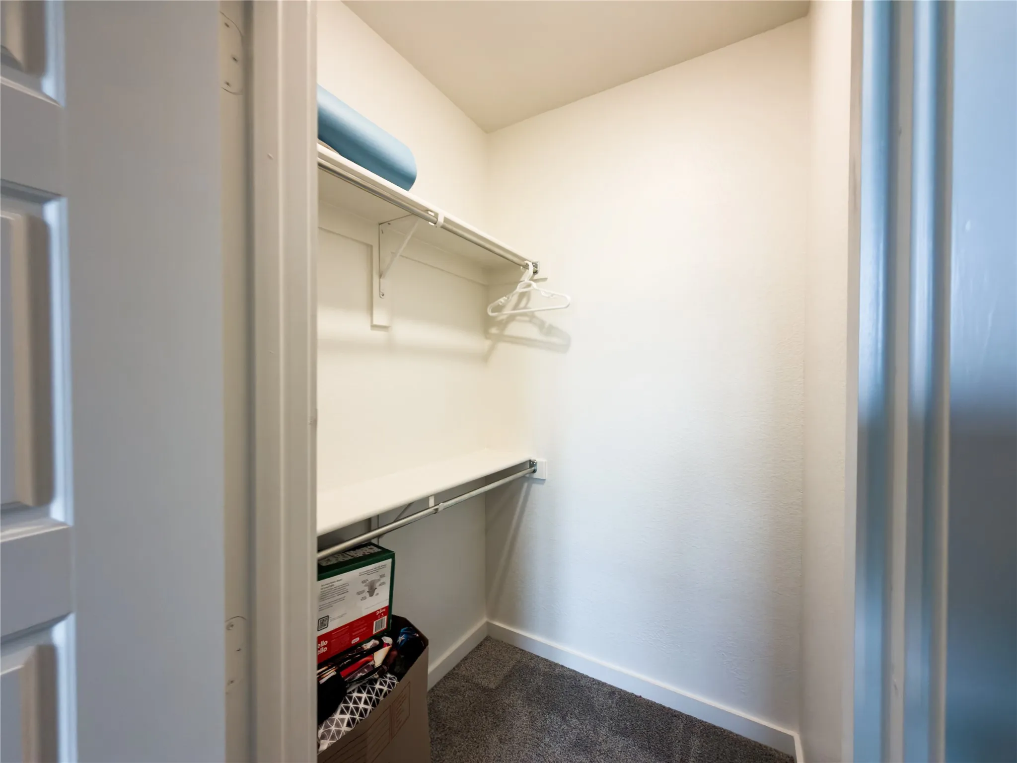 Walk in closet featuring dark carpet