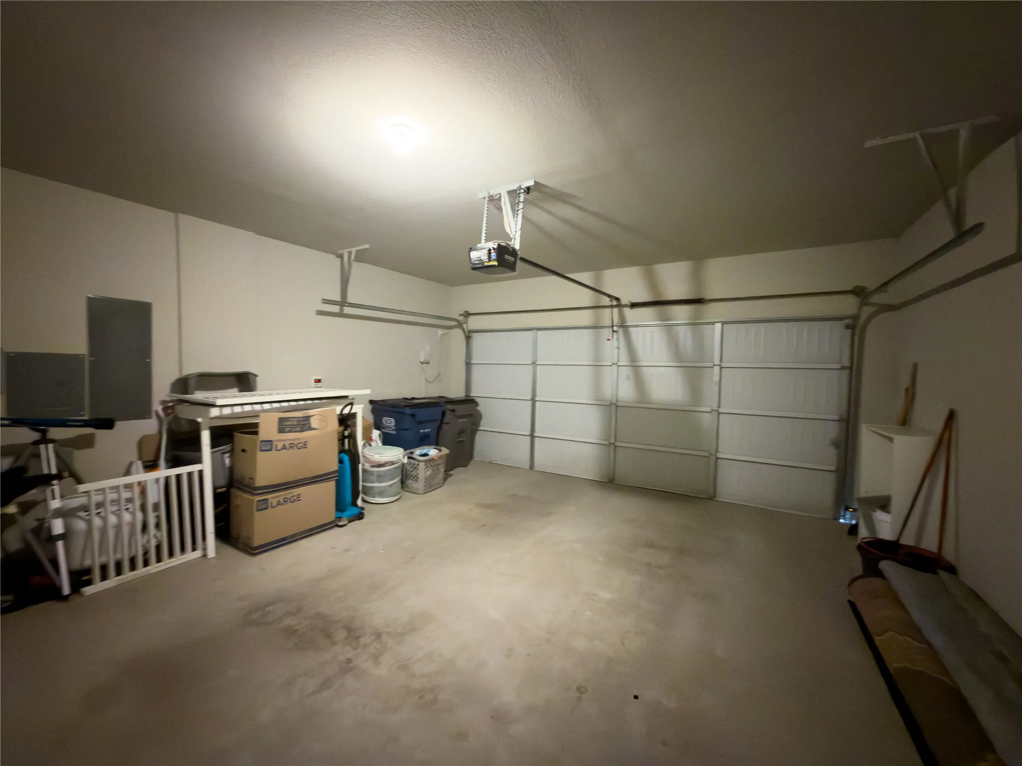 Garage with electric panel and a garage door opener