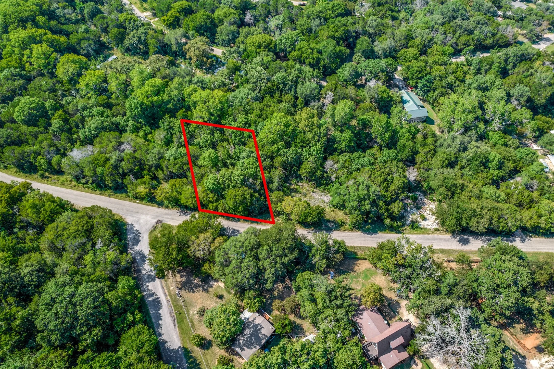 Aerial view of the property, characterized by abundant mature trees and a natural, verdant landscape