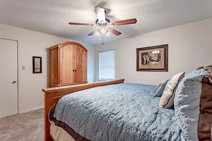 Bedroom featuring carpet, a textured ceiling, and a ceiling fan