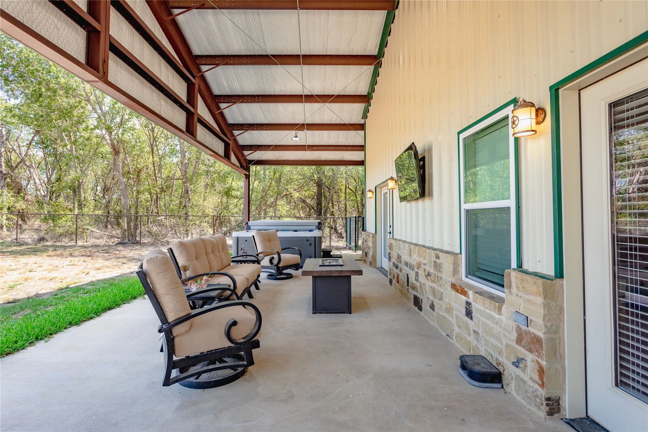 The property features an expansive covered patio with a concrete floor and a hot tub
