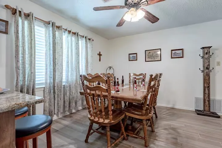 Dining area with dark wood-style floors and ceiling fan