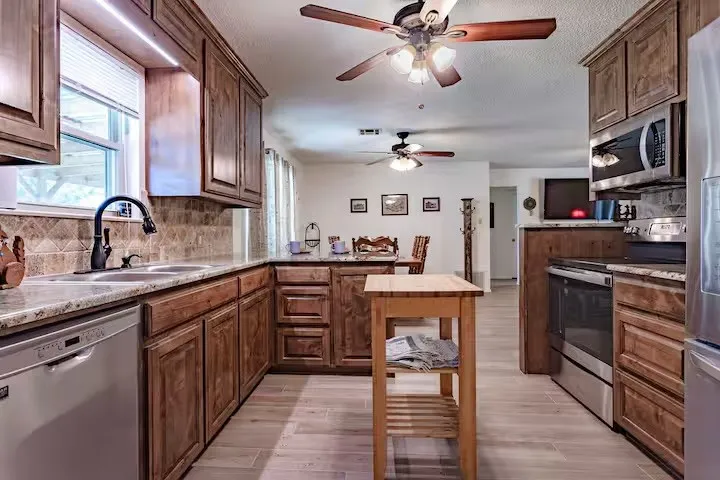 Kitchen with stainless steel appliances, a peninsula, decorative backsplash, and healthy amount of natural light