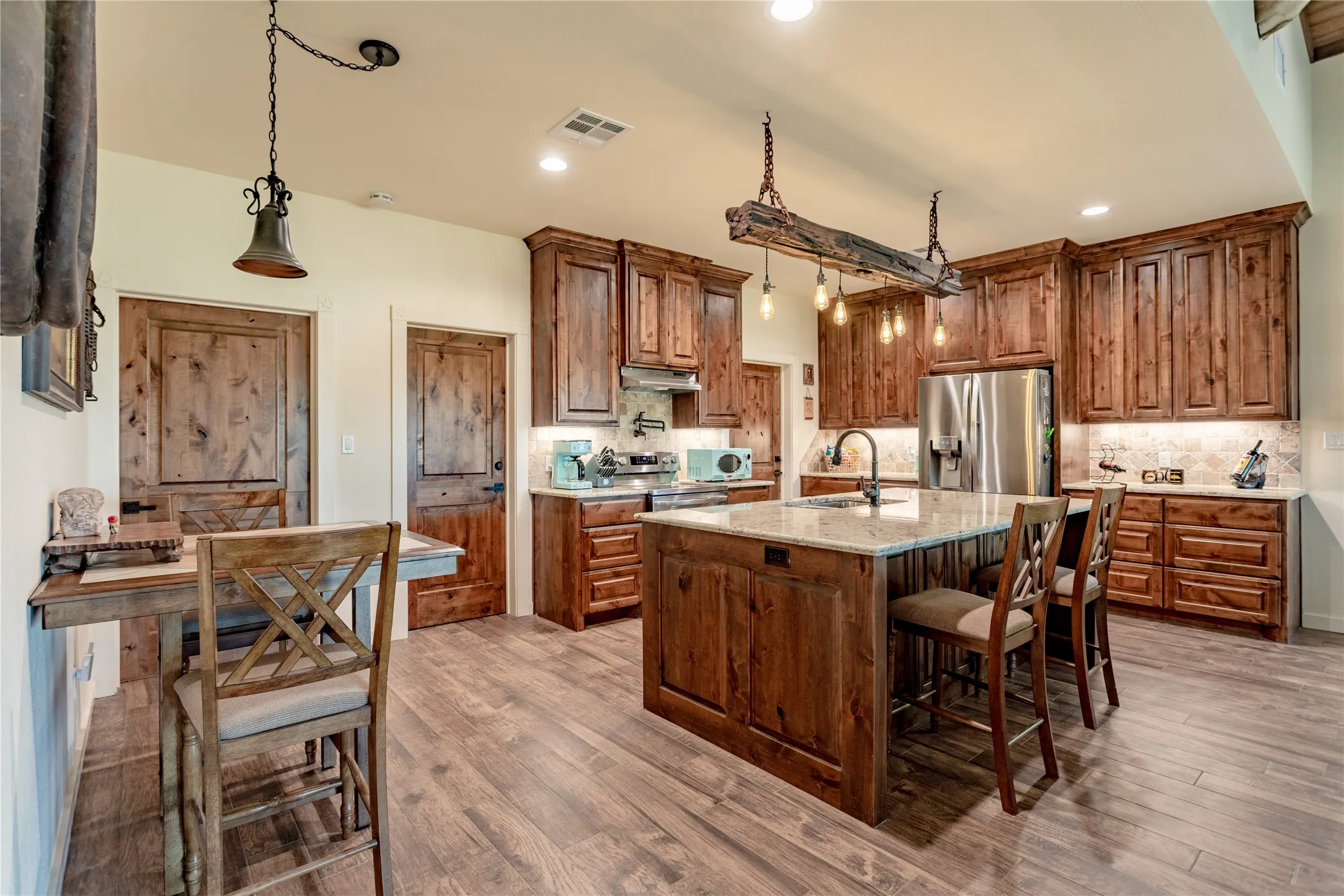 The kitchen features extensive wood cabinetry, a central island with a countertop, and recessed lighting
