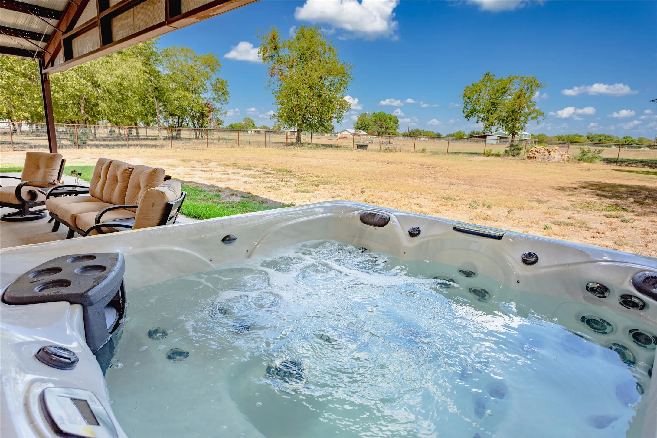 The property features an outdoor spa with bubbling water, set on a concrete patio
