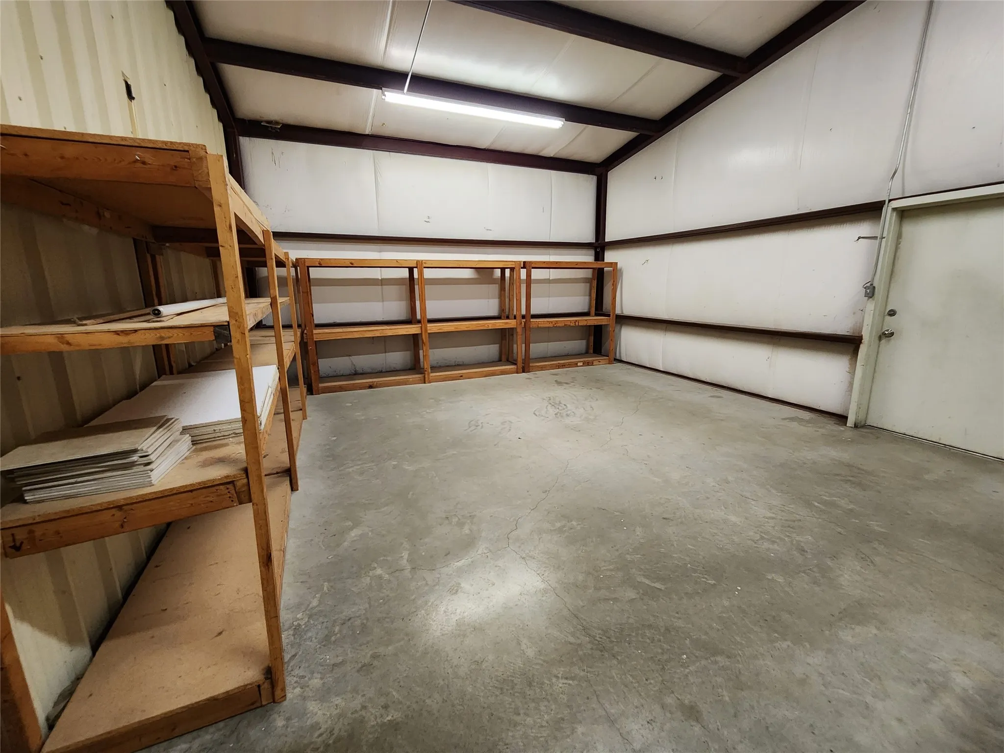 The property features a spacious interior with concrete flooring and exposed metal beam construction
