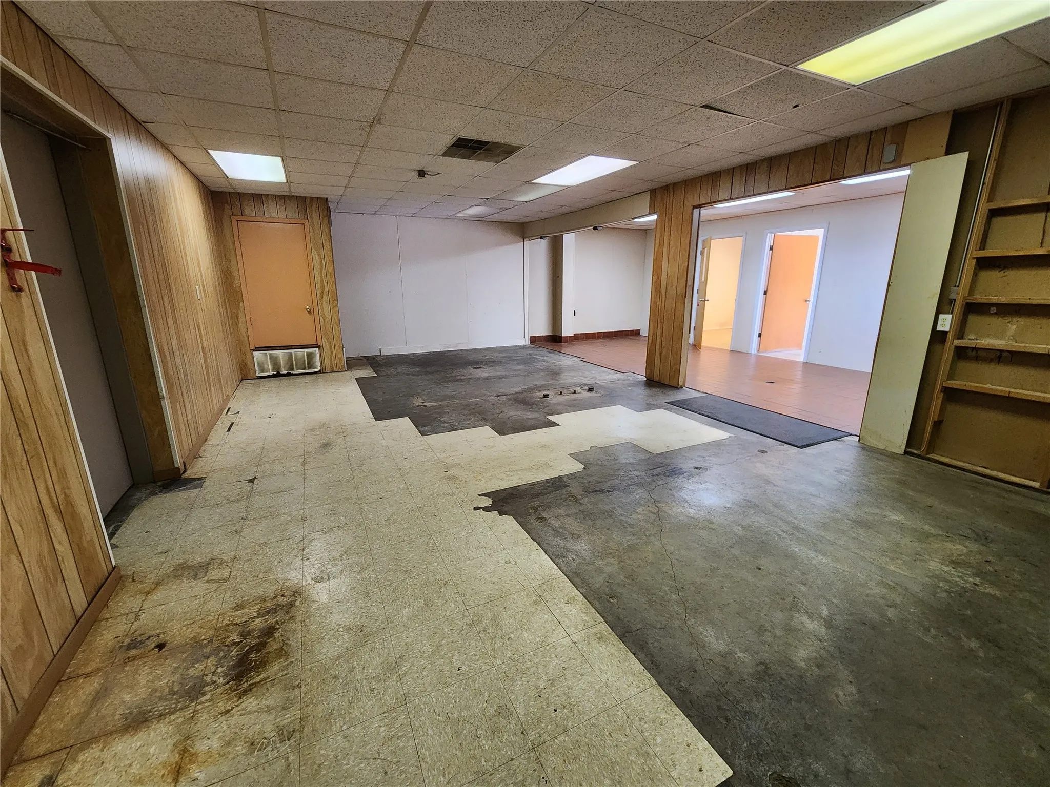 Spacious interior with fluorescent lighting and wood paneling