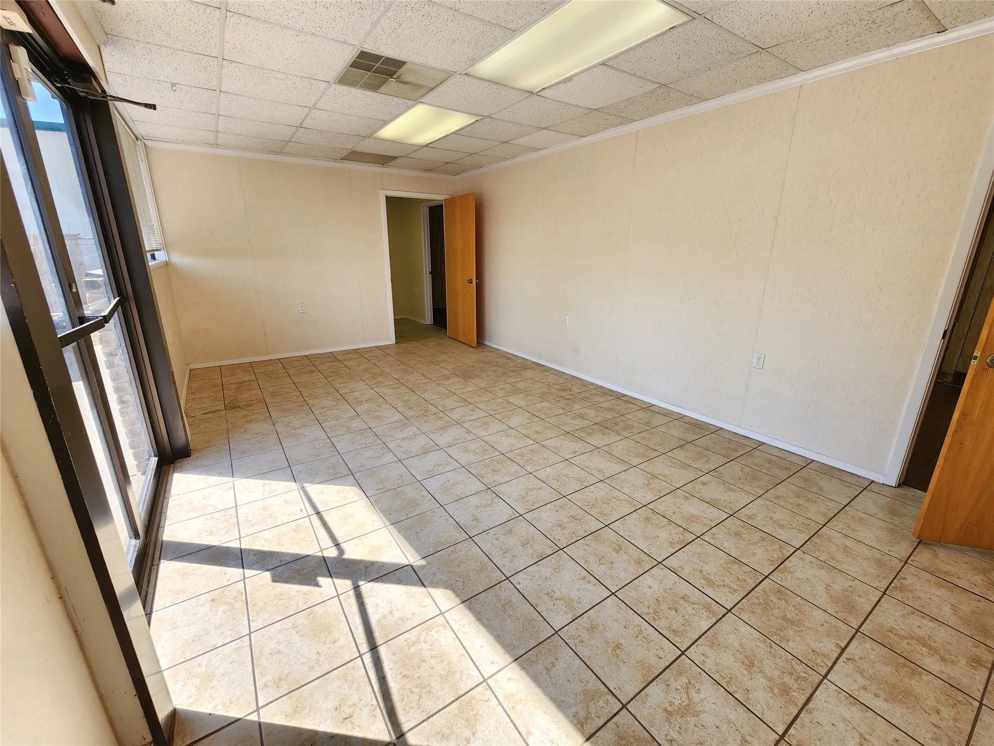 The property features a spacious room with light-colored walls and a tiled floor