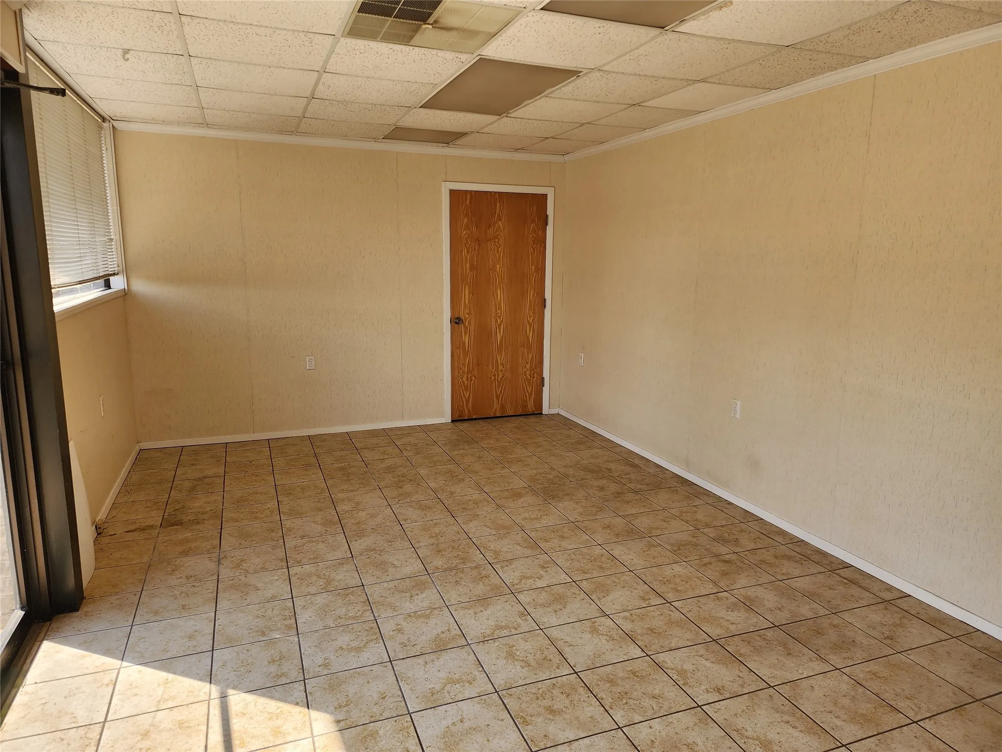 The property features a spacious room with light-colored walls and tiled flooring