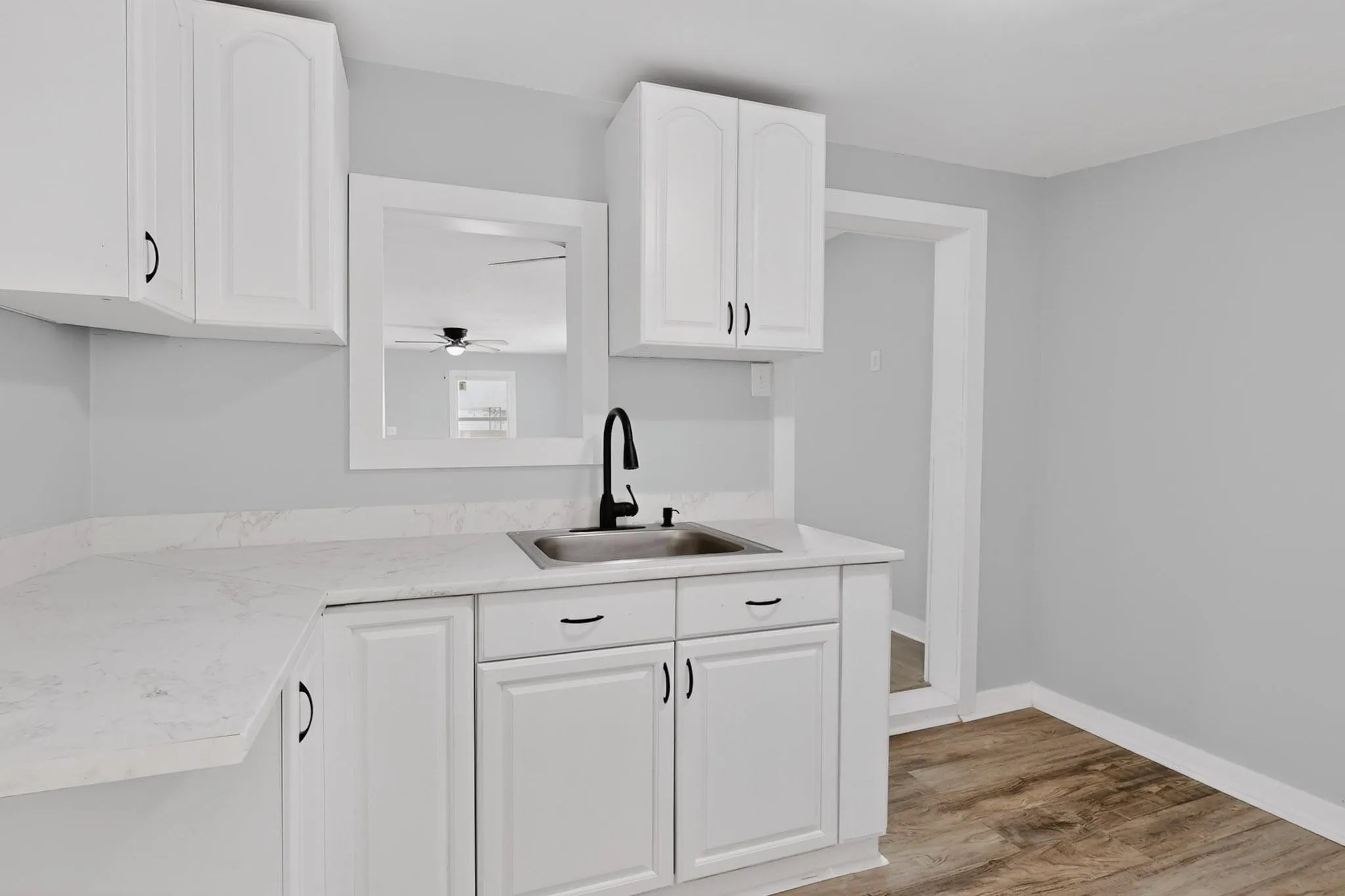 The kitchen features white cabinetry