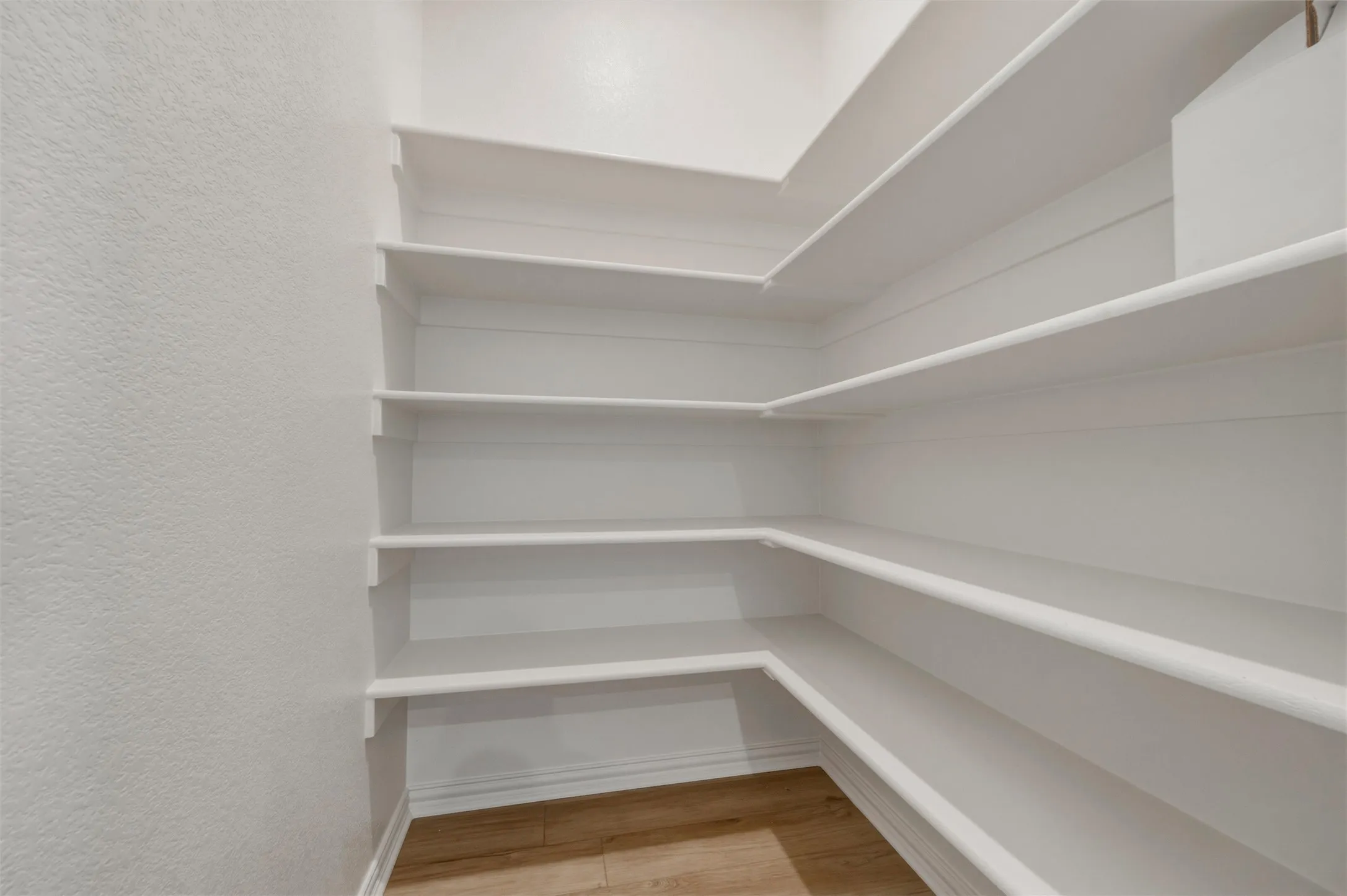 Extensive built-in shelving, white painted finishes, and wood-finish flooring