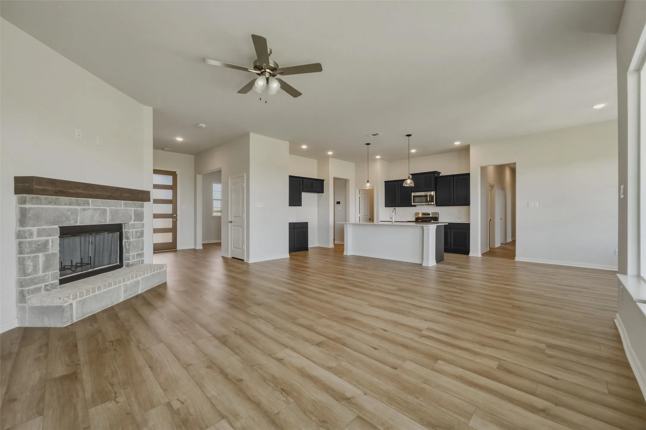 Expansive open-concept living area featuring wood-finish flooring