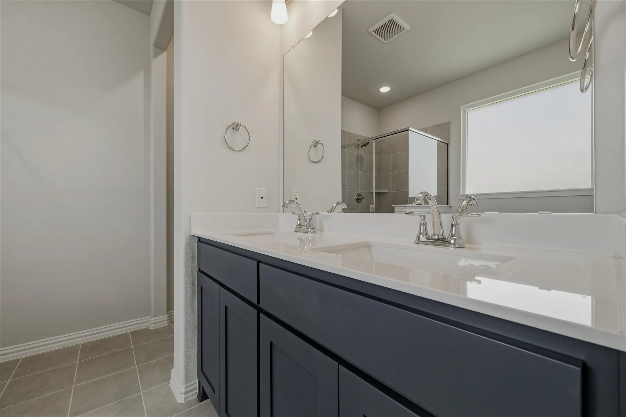 Dual vanity with white countertops, undermount sinks, and chrome fixtures