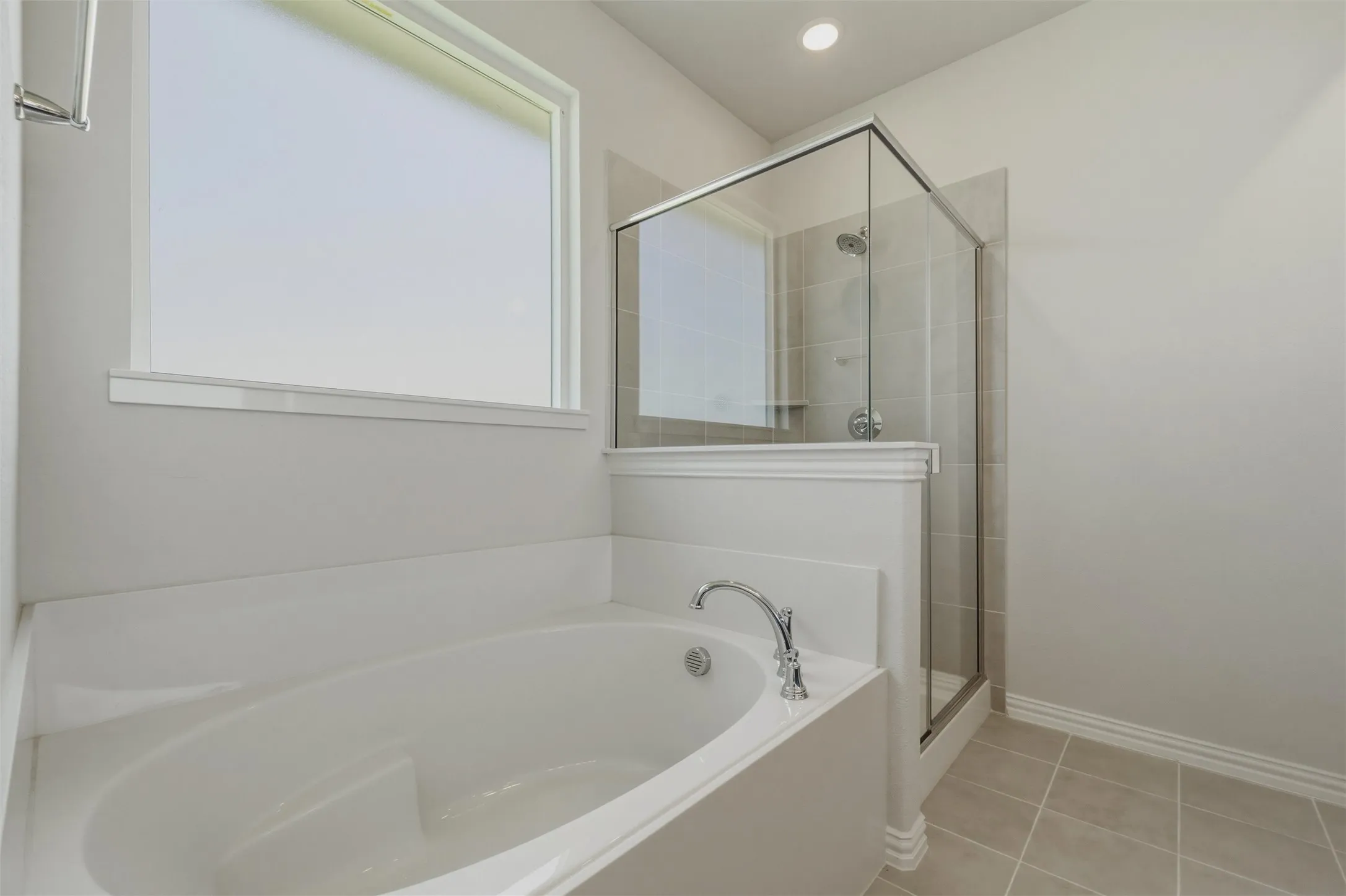 Soaking tub with chrome fixtures, glass-enclosed shower, tiled shower surround, recessed lighting, and tiled flooring