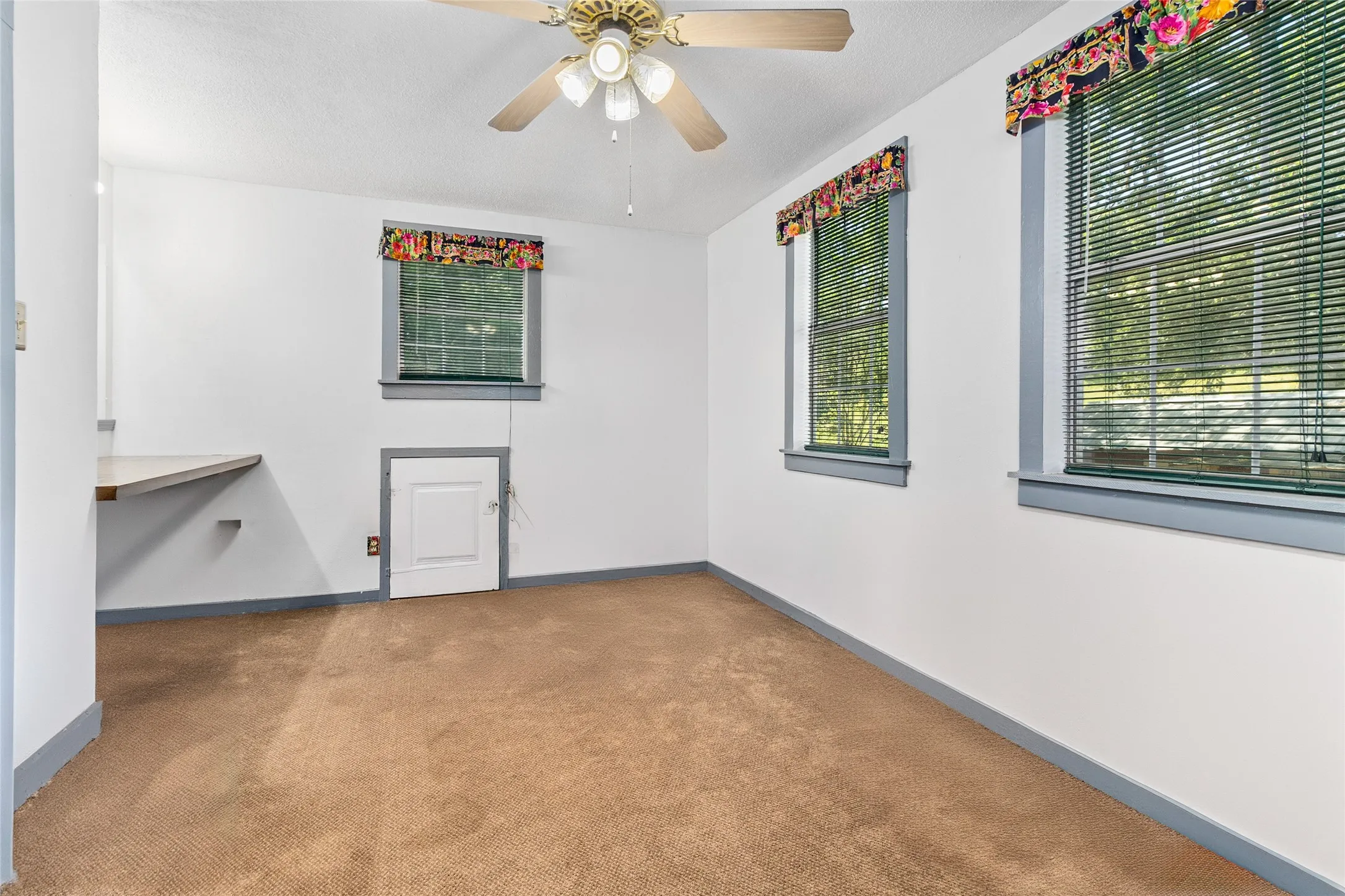 Carpeted empty room featuring ceiling fan