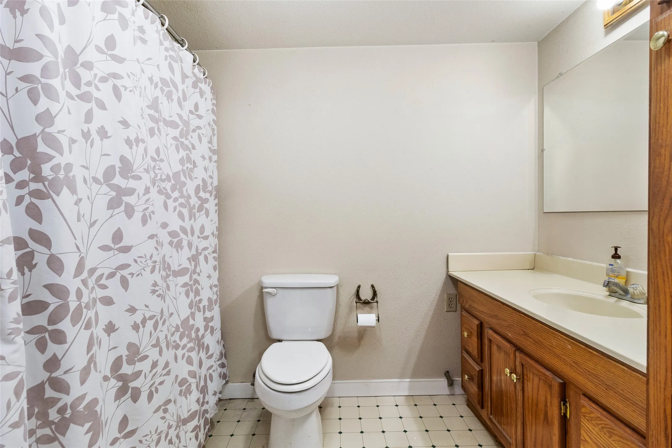 Bathroom featuring tile flooring, large vanity, and toilet