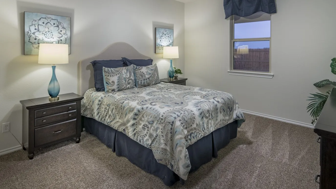 The property features a bedroom with neutral-toned carpet flooring and a window