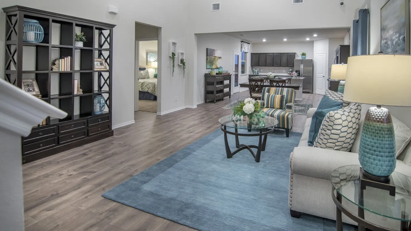 Spacious open-concept living area featuring wood-look flooring and a large area rug
