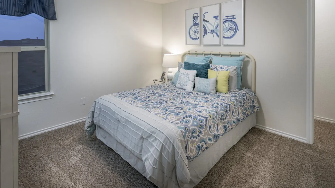 This room features carpeted flooring, a window with a valance, and neutral wall tones