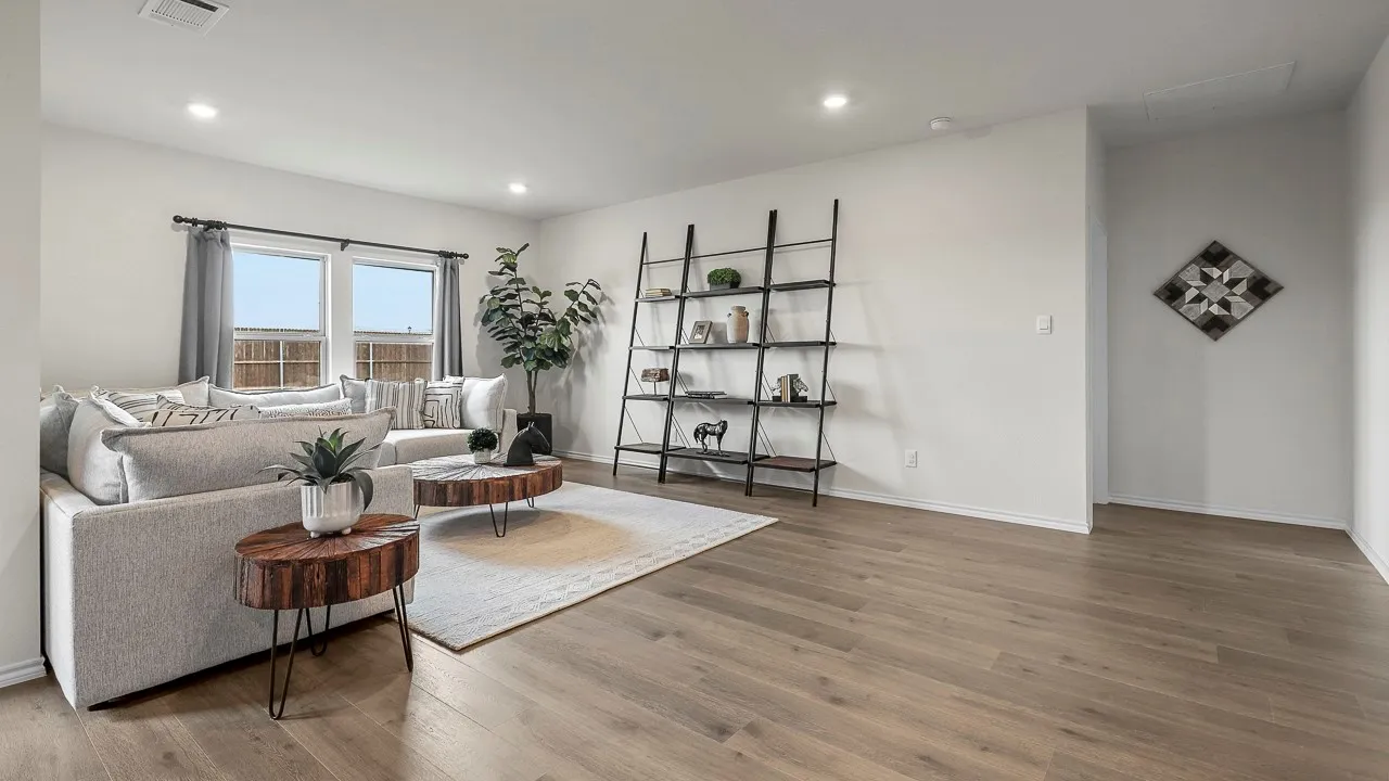 Spacious living area featuring large windows with natural light, recessed lighting, and durable flooring