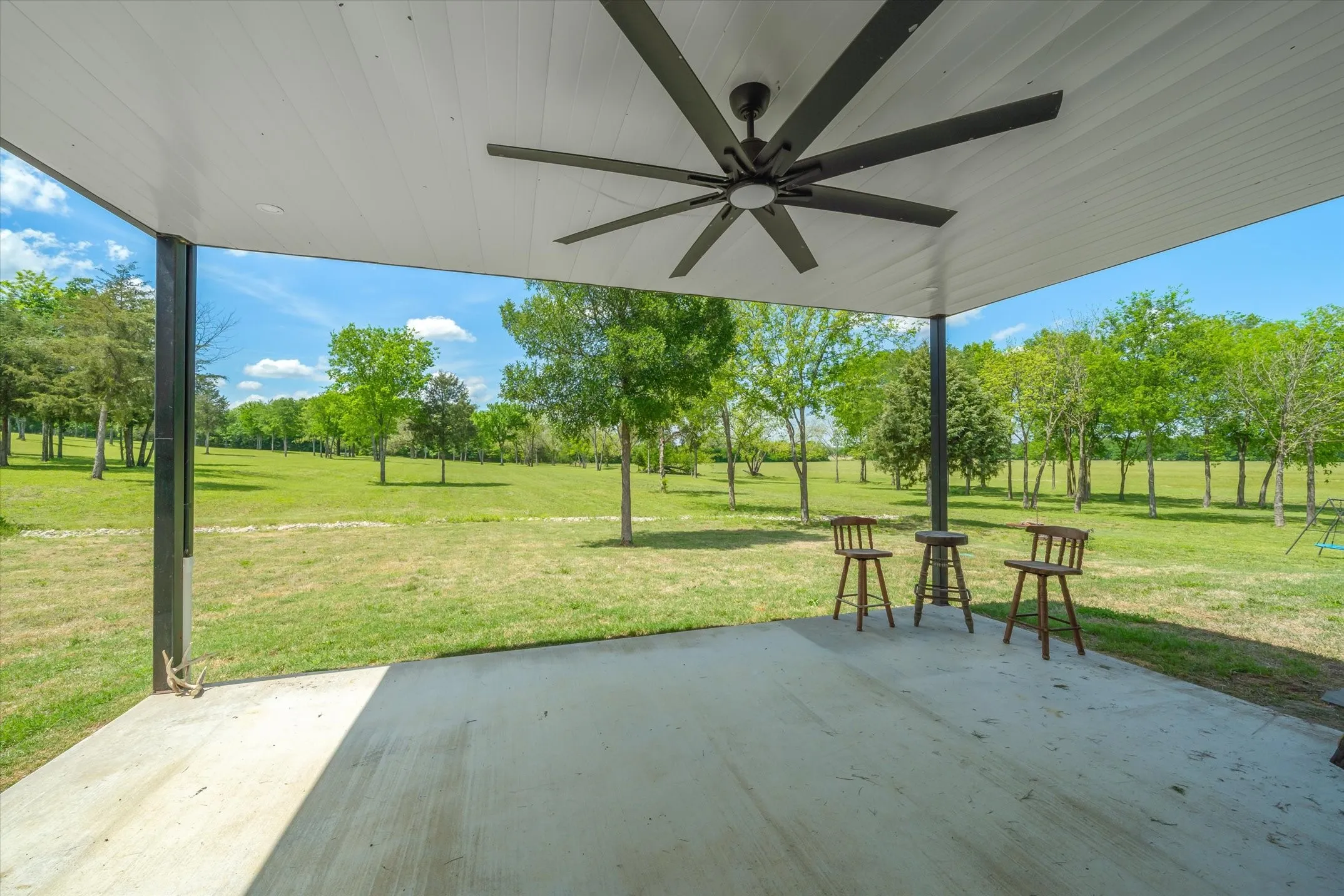 Covered patio off the large barndominium has all the gorgeous views