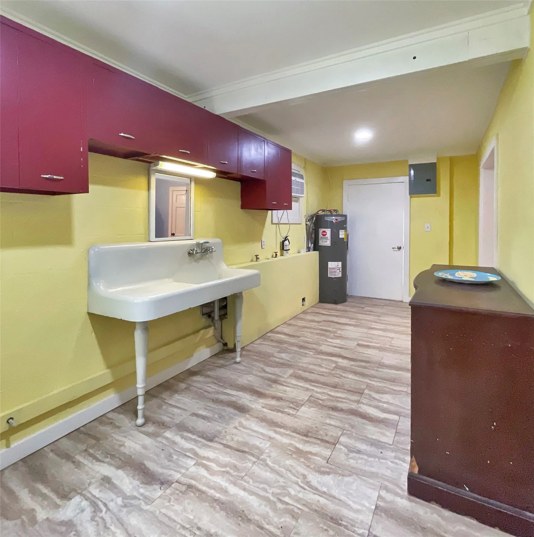 laundry room with hot  water heater. Door leading to covered patio