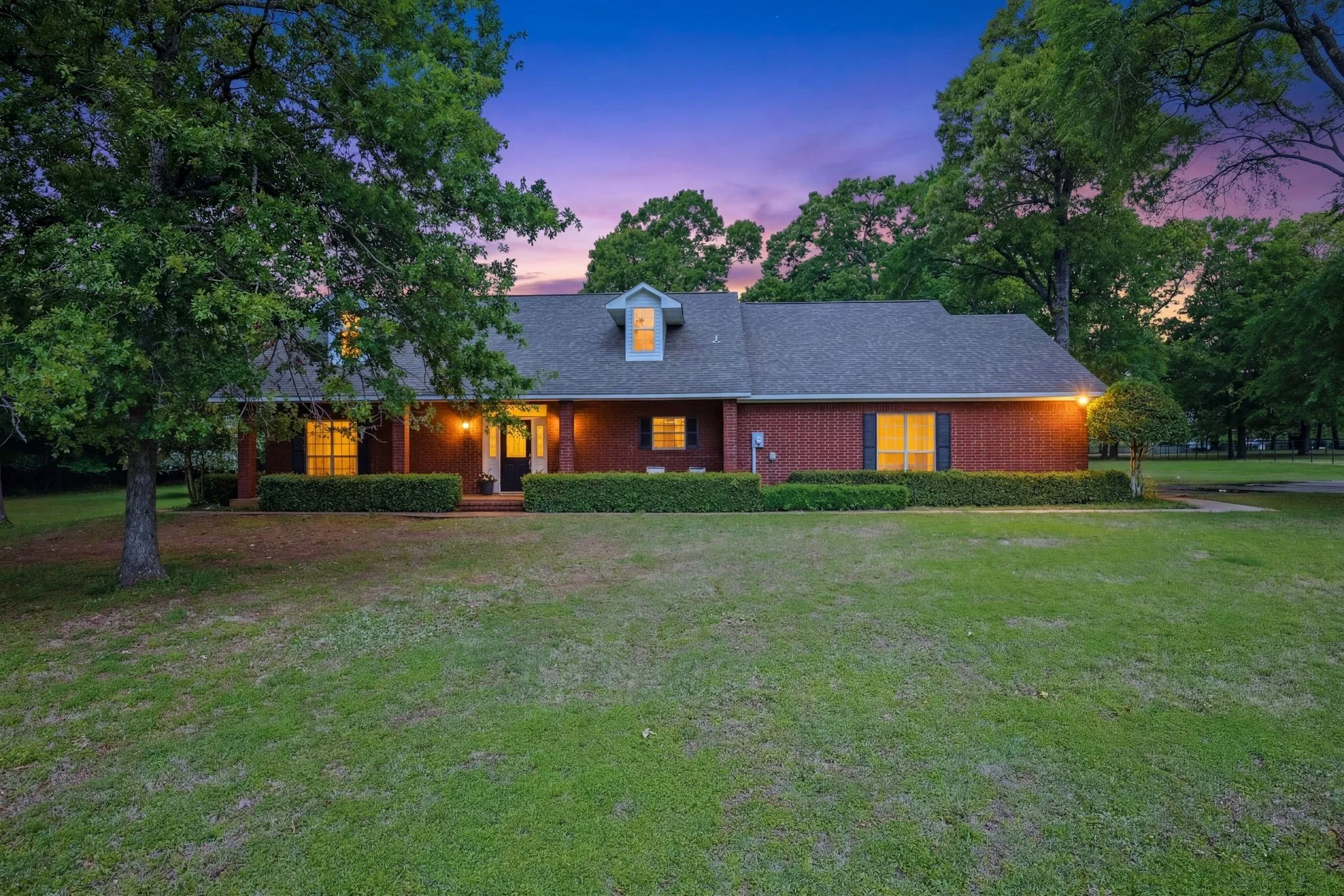 The property features a brick exterior with a dark-colored roof and a dormer window