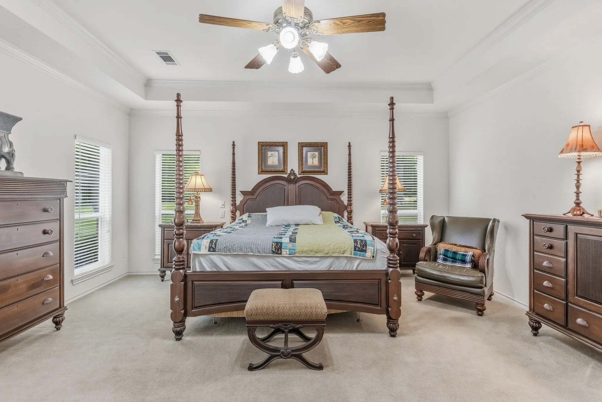 The room features light-colored carpeting, white walls, and a tray ceiling