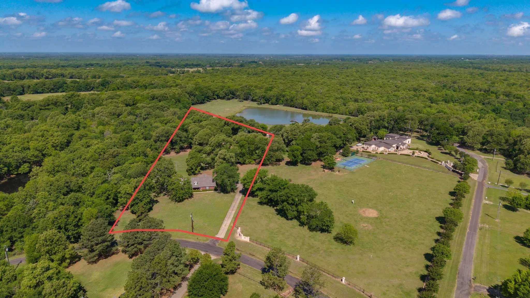 The property features a private drive and is surrounded by mature trees, creating a serene environment
