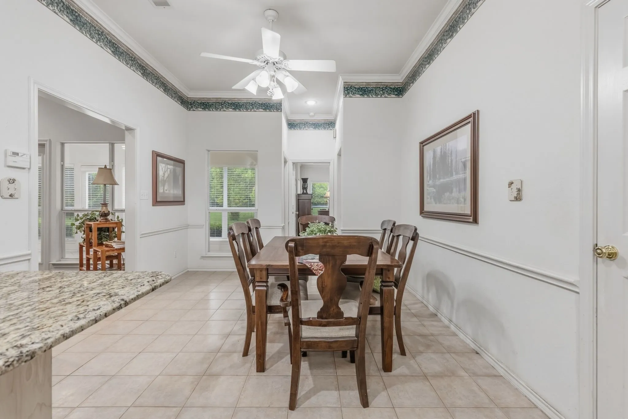 Dining area featuring tile flooring, a ceiling fan, and decorative molding