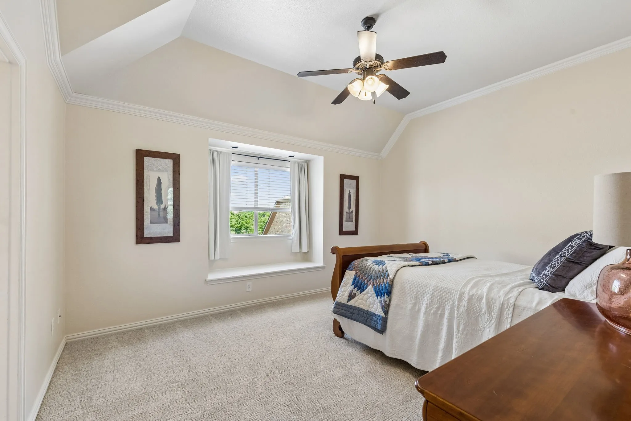 This room features a vaulted ceiling, a ceiling fan, and carpet flooring
